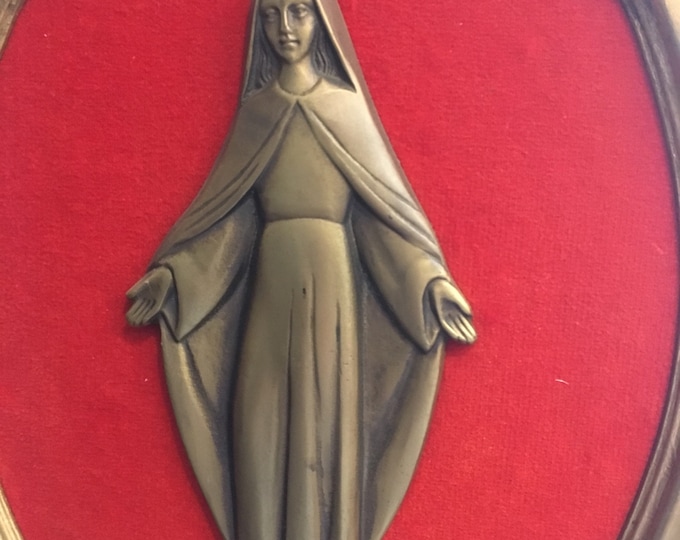 Oval painting of the Virgin Mary in bronze art on red velvet
