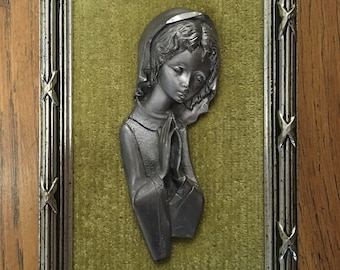 Painting in pewter and green velvet of a child who prays for communion or baptism.