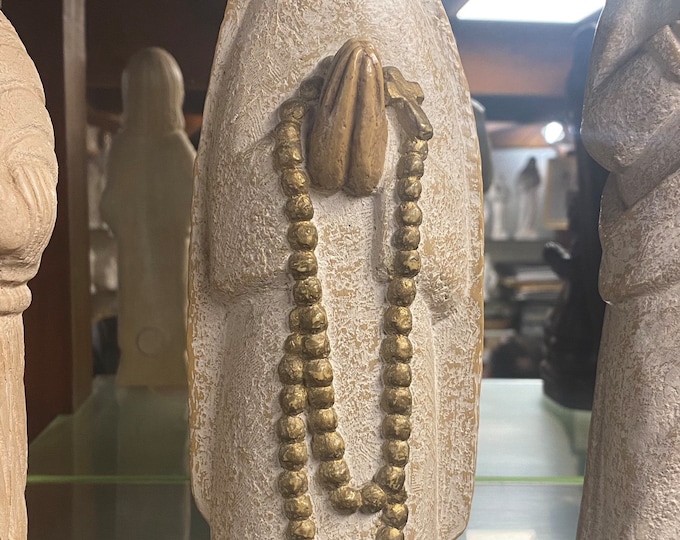 Statue of the Virgin Mary in stone holding a rosary