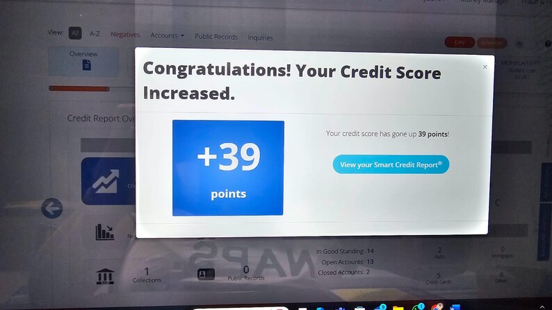 May include: A computer screen shows a pop-up message: "Congratulations! Your Credit Score Increased." A blue square displays "+39 points." The text "View your Smart Credit Report" is visible. The screen shows credit report details.