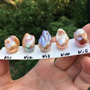 May include: Five iridescent baroque pearls, labeled V11, V12, V13, V14, and V15, are displayed on a white card.