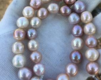 May include: A strand of pearls with a mix of white and pink hues. The pearls are round and have a smooth, glossy finish.