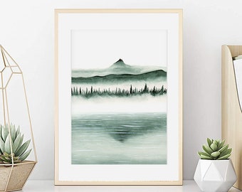 Può includere: Un dipinto ad acquerello incorniciato di una catena montuosa con un lago in primo piano. Il dipinto è in tonalità di verde e blu, e le cime delle montagne sono oscurate dalla nebbia. Il dipinto è appeso a una parete bianca, e ci sono due piccole piante in vaso sullo scaffale sottostante.