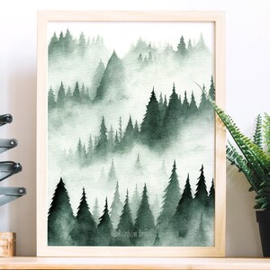 May include: A watercolor painting of a misty forest scene with green trees and fog. The painting is framed in a light wood frame.