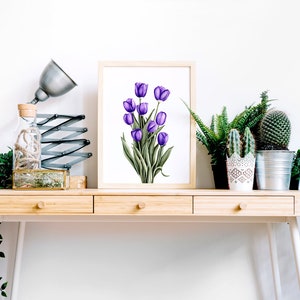 May include: A framed print of a watercolor painting of purple tulips on a white background. The print is displayed on a wooden desk with a lamp, a glass bottle, and potted plants.