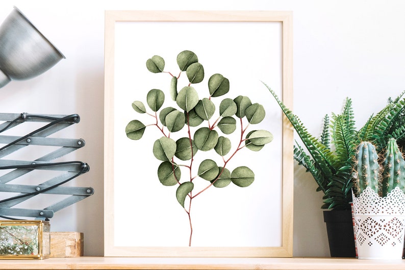 May include: A framed watercolor painting of a eucalyptus branch with green leaves on a white background.