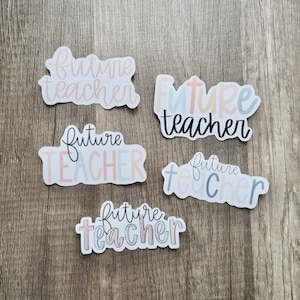 May include: Five stickers with the text "future teacher" in different colors and fonts. The stickers are on a wood background.
