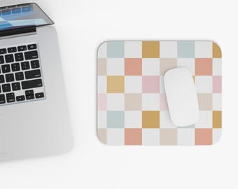 Peut inclure: Un tapis de souris blanc avec un motif à carreaux en rose pastel, bleu et jaune. Une souris d'ordinateur blanche est sur le tapis de souris.