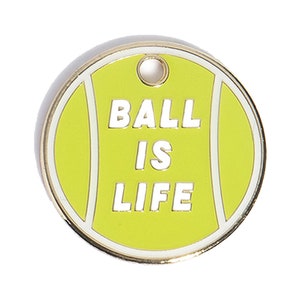 Könnte beinhalten: Ein gelber Tennisball mit weißem Rand und dem Text "BALL IS LIFE" in weißen Buchstaben.