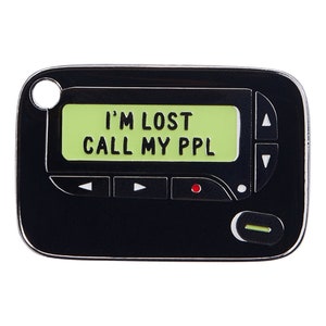 May include: Black and white enamel pin shaped like a vintage pager with the text "I'M LOST CALL MY PPL" on the screen.