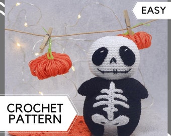 May include: Crochet pattern for an easy to make skeleton amigurumi toy. The toy is wearing a black and white skeleton costume and has a white face with black eyes. The pattern is labeled "EASY" and "CROCHET PATTERN".
