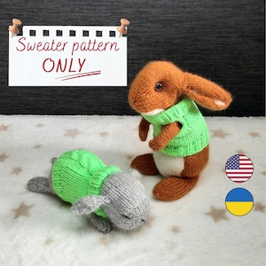 Puede incluir: Dos figuras de conejito de punto, una de pie y otra tumbada, ambas con suéteres verdes. El conejito de pie es marrón y blanco, mientras que el otro es gris. Un letrero arriba dice "Sweater pattern ONLY".