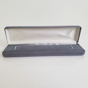 Grijs fluwelen sieradenpresentatiedoos voor ketting, horloge of armband, grijze en crèmekleurige binnenkant, rechthoekige sieradendoos