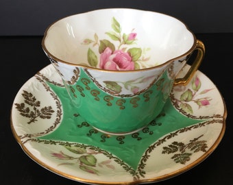 Taza y platillo vintage de EB Foley: Verde repujado con rosas rosas y detalles dorados.