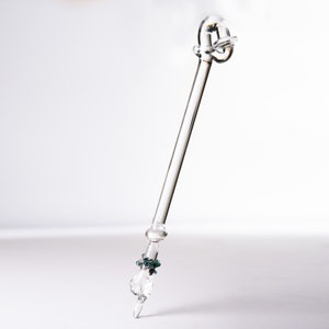 Może przedstawiać: Pióro kaligraficzne ze szkła transparentnego z ozdobnym węzłem na górze i zielonym szklanym koralikiem na dole.