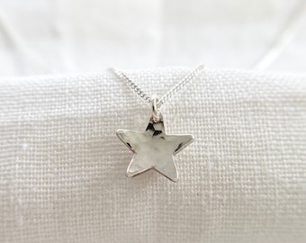 May include: A silver necklace with a hammered star pendant.