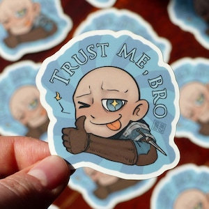 Peut inclure: Un autocollant bleu et blanc avec un personnage de dessin animé donnant un pouce en l'air. Le personnage a la tête chauve, les yeux bleus et la langue qui sort. Le texte sur l'autocollant dit "Fais-moi confiance, mec".