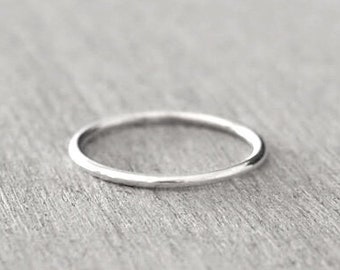 Può includere: Un anello semplice a fascia in argento con una finitura liscia e lucida.