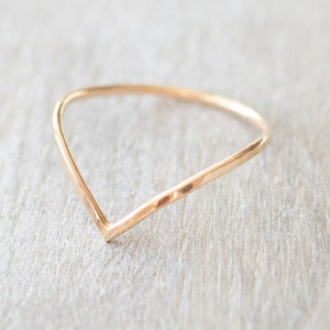 Puede incluir: Un anillo de oro simple con un dise&ntilde;o en forma de V. El anillo est&aacute; hecho de metal martillado, lo que le da un aspecto texturizado.