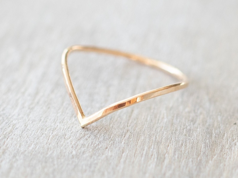 Puede incluir: Un sencillo anillo de oro en forma de V. El anillo est&aacute; hecho de un metal fino y martillado.