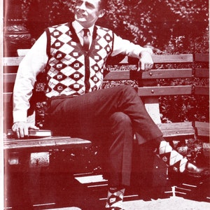 May include: A man wearing a white shirt and a black and white diamond patterned waistcoat sits on a wooden park bench. He is wearing black trousers and white and black diamond patterned socks.