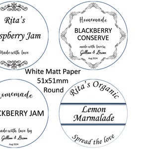 May include: Four round white labels with black text and decorative borders. The labels are for homemade jams and marmalades. The labels read: "Rita's Raspberry Jam", "Homemade Blackberry Conserve", "Homemade Blackberry Jam", and "Rita's Organic Lemon Marmalade".