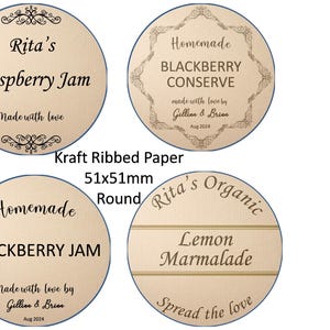 May include: Four round kraft paper labels with a ribbed texture. The labels are 51mm in diameter and feature different designs for homemade jams and marmalades. The labels include text such as "Rita's Raspberry Jam", "Homemade Blackberry Conserve", "Homemade Blackberry Jam", and "Rita's Organic Lemon Marmalade".