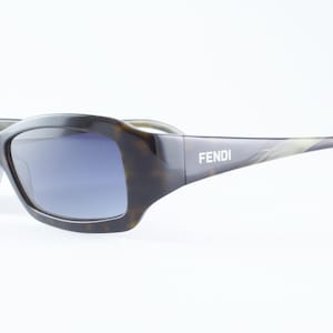 May include: A set of three ceramic mugs with a speckled, matte finish. The mugs are in shades of cream, light gray, and dark gray. Each mug has a simple, minimalist design and a rounded handle.