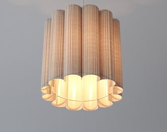 May include: A white ceiling-mounted light fixture with a beige fabric shade. The shade is made of multiple vertical strips of fabric that are curved at the bottom, creating a scalloped edge.