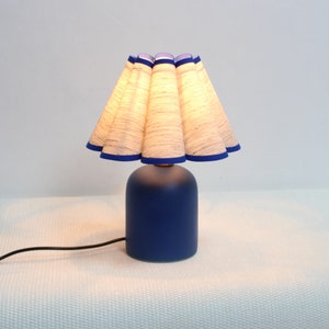 Ręcznie robiona lampa stołowa z szarej tkaniny z teksturą i niebieską ceramiczną podstawą