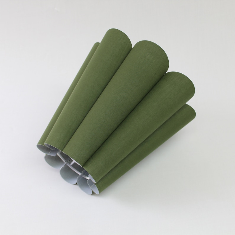 May include: A green lampshade made of fabric with a pleated design.