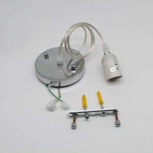 May include: A chrome ceiling light fitting with a white cord and a white lamp holder. The holder has the text "MAX 200W" printed on it. The fitting comes with two yellow plastic anchors and two silver screws.