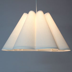May include: A white, fabric pendant light fixture with a pleated, cone-shaped shade.