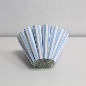 Pu&ograve; includere: Un ventaglio di carta blu e bianco, piegato a forma di cono.