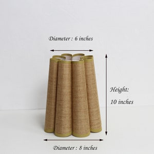 May include: A brown lampshade with a pleated design and a green trim. The lampshade is 6 inches in diameter at the top and 8 inches in diameter at the bottom. It is 10 inches tall.