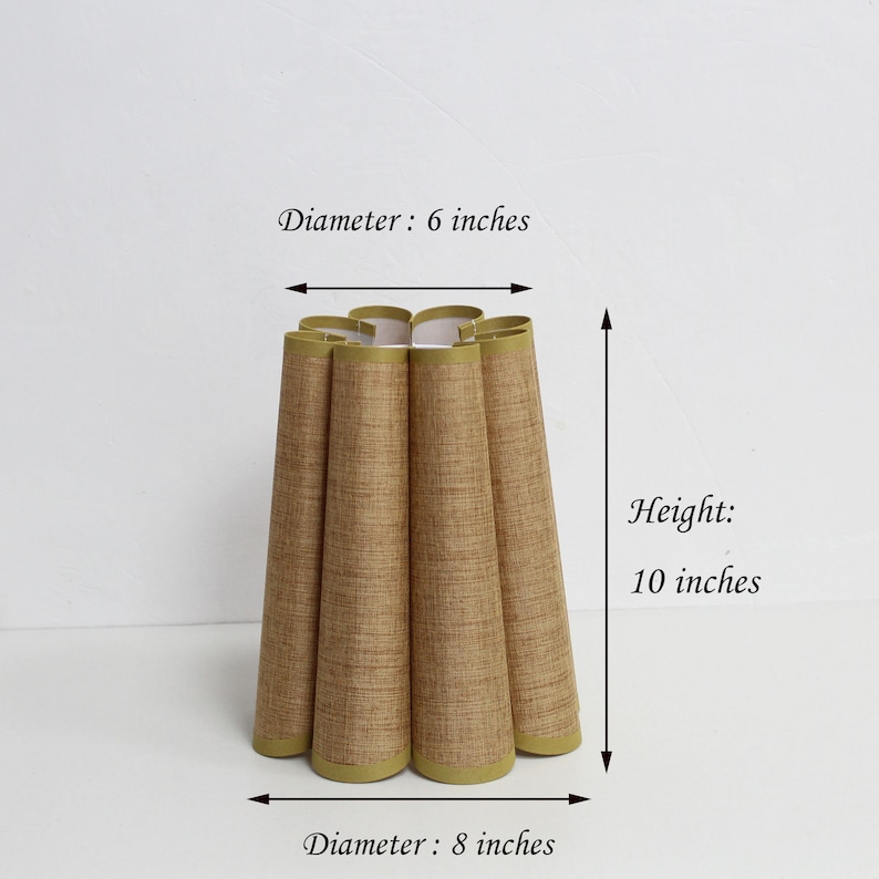 May include: A brown lampshade with a pleated design and a green trim. The lampshade is 6 inches in diameter at the top and 8 inches in diameter at the bottom. It is 10 inches tall.