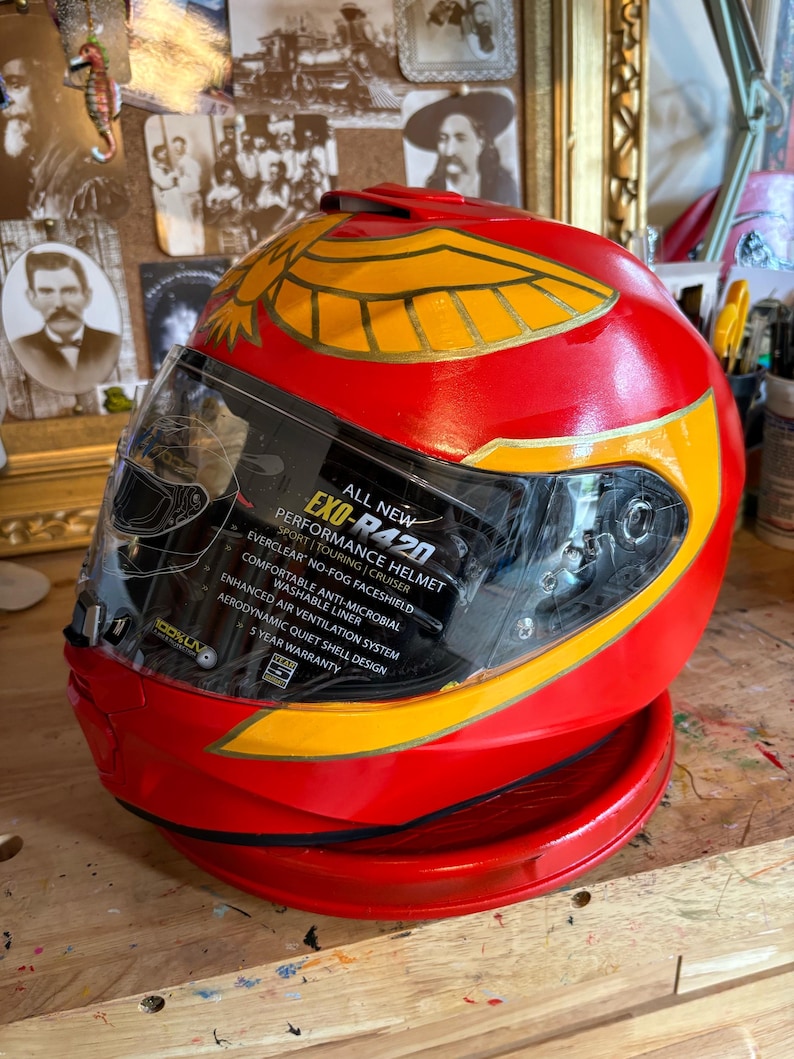 May include: Red motorcycle helmet with a gold eagle design and a clear visor. The helmet has the text "ALL NEW EXO-R420 PERFORMANCE HELMET" on the visor.