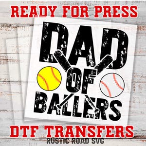 May include: Black and white graphic design with the text "Dad of Ballers" and two baseballs. The text has a distressed look. The graphic is ready for heat transfer.