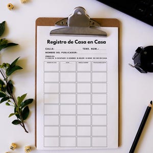 May include: A clipboard with a printed form titled "Registro de Casa en Casa" in Spanish. The form has sections for address, publisher's name, and symbols. A black pencil, keyboard, and dice are also visible.