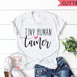May include: A white t-shirt with a black and pink design that says "Tiny Human Tamer".