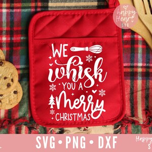 May include: Red pot holder with a white design that says "We whisk you a Merry Christmas" with a whisk illustration.