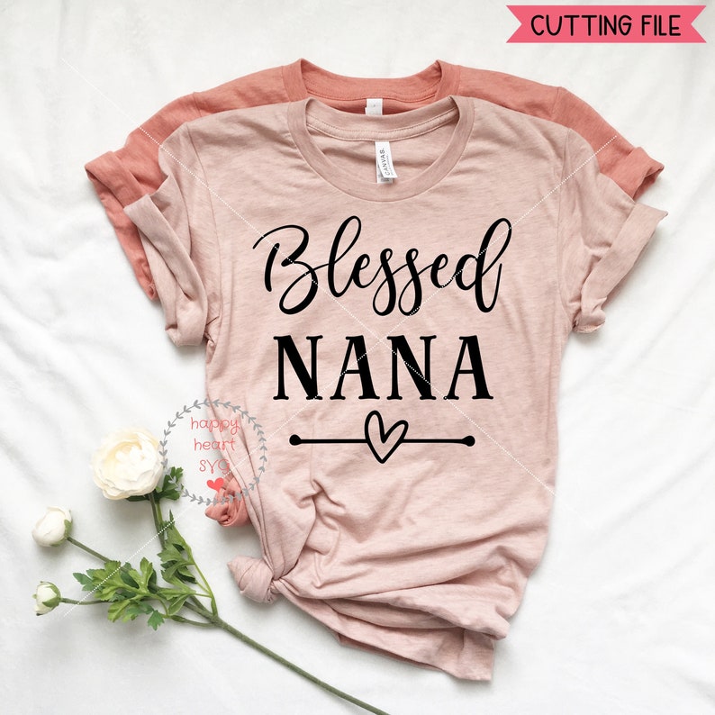 May include: A pink t-shirt with the text "Blessed Nana" in black lettering. A small heart is drawn below the text with a line extending to each side.