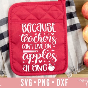 May include: Red quilted hot pad with the text "Because teachers can't live on apples alone" in white. The hot pad is on a wooden surface with three red apples.