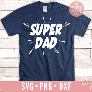 K&ouml;nnte beinhalten: Ein marineblaues T-Shirt mit dem Text "SUPER DAD" in Wei&szlig;, mit einem wei&szlig;en Sternenausbruch-Design um den Text.