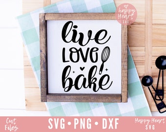 May include: A wooden sign with the text "live love bake" in black cursive font. A black whisk is pictured next to the word "love".