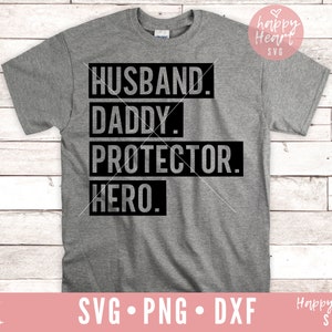 May include: A gray t-shirt with black text that reads "Husband. Daddy. Protector. Hero."