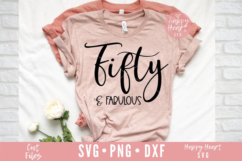 May include: A pink t-shirt with the text "fifty & fabulous" in black script font.