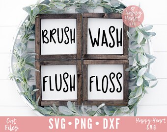 May include: Four wooden signs with white backgrounds and black text. The signs read "Brush", "Wash", "Flush", and "Floss". The signs are arranged in a square shape and are surrounded by a wreath of greenery.