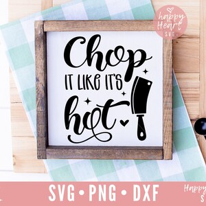 Peut inclure: Une pancarte en bois avec le texte "Chop it like it's hot" en écriture cursive noire. Une silhouette noire d'un couteau de chef est à côté du texte. La pancarte est sur un fond à carreaux vert et blanc.