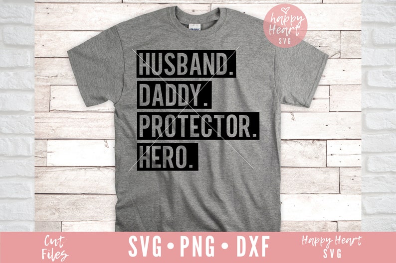 K&ouml;nnte beinhalten: Ein graues T-Shirt mit schwarzem Text, der "Husband. Daddy. Protector. Hero." lautet.
